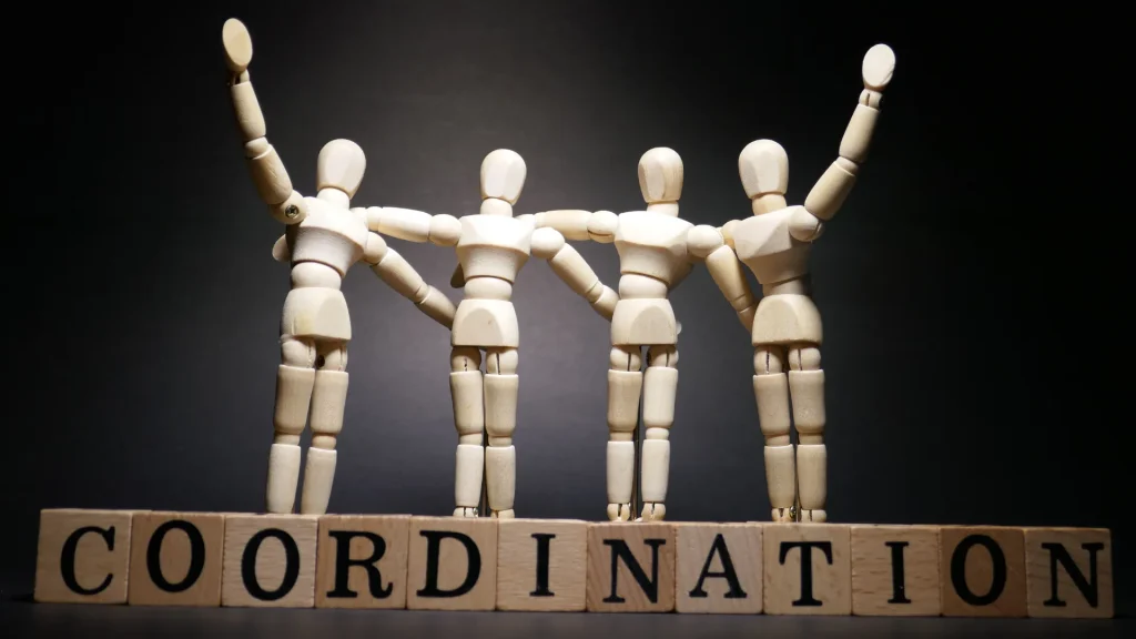  Wooden figures representing teamwork with "COORDINATION" text, symbolizing the role of a digital marketing coordinator salary and career growth.
