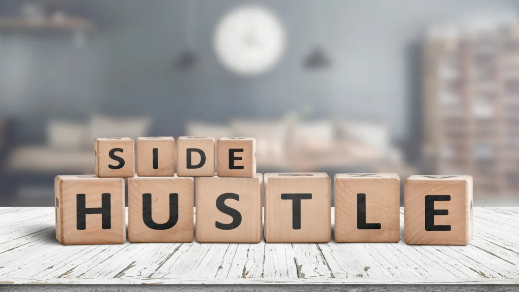 Wooden blocks spelling "Side Hustle" on a blurred background, symbolizing the concept of a digital marketing side hustle.