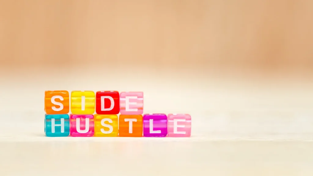 Colorful beads spelling "Side Hustle" on a soft background, representing fun and engaging ways to earn through digital marketing side hustle.